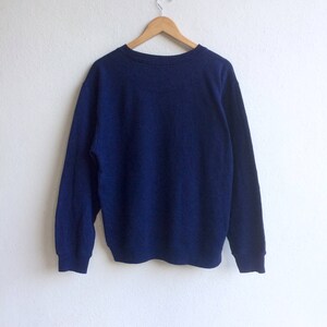 May include: A navy blue long-sleeved sweatshirt with a crew neck.