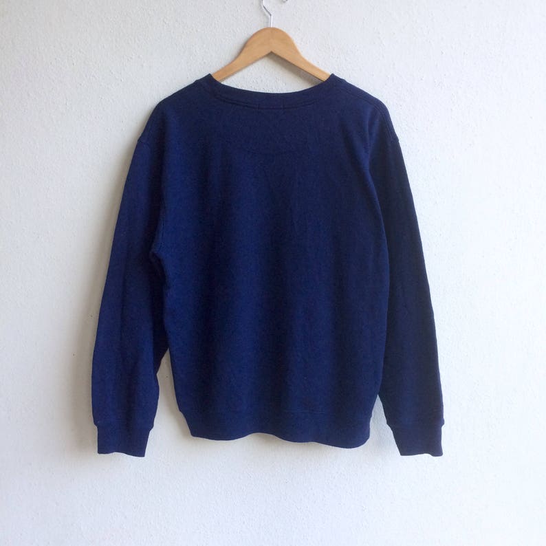 May include: A navy blue long-sleeved sweatshirt with a crew neck.