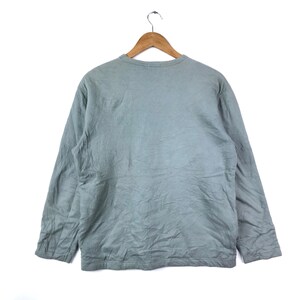 Op de afbeelding: Een lichtgrijs longsleeve shirt met een ronde hals.