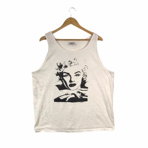 May include: White sleeveless tank top with a black and white image of Marilyn Monroe on the front.