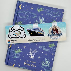 May include: A set of three magnetic bookmarks featuring a Disney Cruise Line ship, a Mickey Mouse pirate character, and a heart-shaped hand gesture. The bookmarks are attached to a blue and white book with a Peter Pan design.