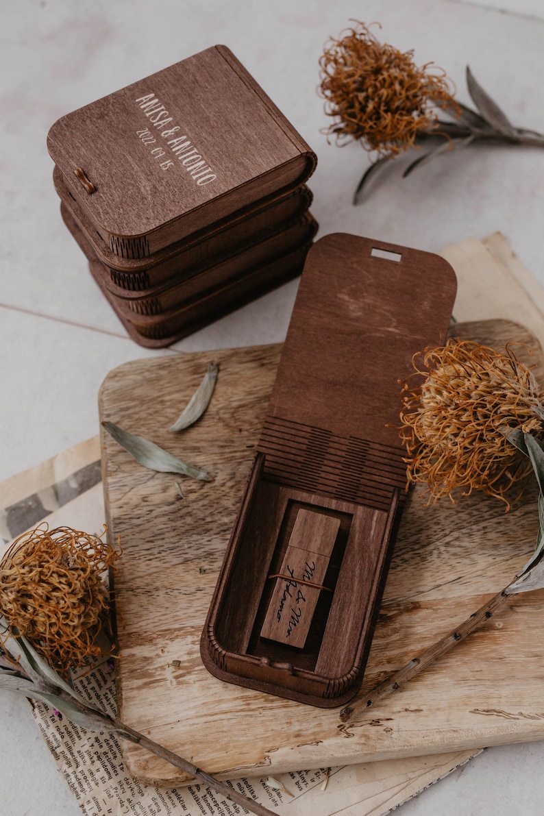 May include: A wooden box with a USB drive inside. The box is engraved with the text "Anisa & Antonio 2022-09-15" and the USB drive is engraved with the text "M&M damo".