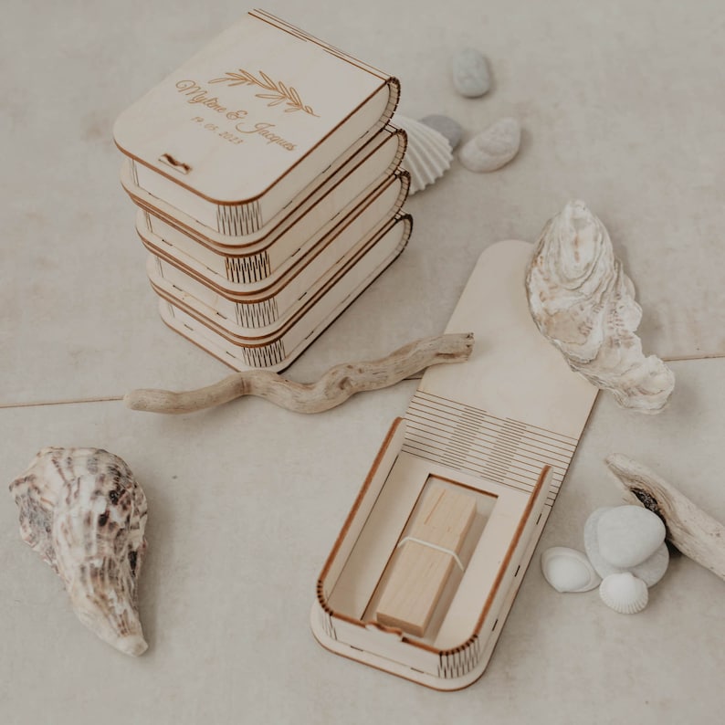 May include: A stack of four wooden boxes with a delicate floral design and the text "Myles & Jasmine 18.08.2021". The boxes are open to reveal a wooden USB drive inside.