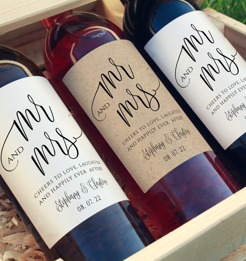 May include: Three wine bottles with personalized labels that say "Mr. and Mrs." with the couple's names and wedding date. The labels are printed on a kraft paper background.