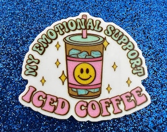 Könnte beinhalten: Ein weißer Aufkleber mit einem rosa und braunen Eiskaffeebecher mit einem Smiley. Der Text um den Becher lautet "My Emotional Support Iced Coffee".