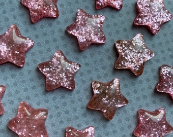 20 piezas. Estrella de brillo rosa, cabujón de resina, espalda plana