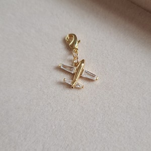 Airlplane charm perfect as a gift for a person going on an adventure traveling the world or a special pilot friend. The charm is real gold filled with circonia as wings giving the charm a special touch. Each charm comes with a clasp.