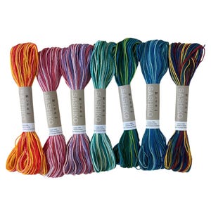 May include: Seven skeins of Sashiko thread in a range of colours, including orange, pink, green, and blue. Each skein is wrapped with a paper label with Japanese text. The threads are made of cotton.