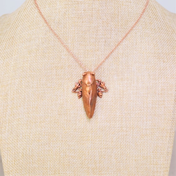 A real cicada encased in electroformed copper on an Art Nouveau–style pendant — each one is literally a unique insect, zero chance two are identical.