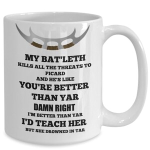 May include: White ceramic coffee mug with a black and white graphic of a Klingon Bat'leth and text that reads "My Bat'leth kills all the threats to Picard and he's like you're better than yar damn right I'm better than yar I'd teach her but she drowned in tar."