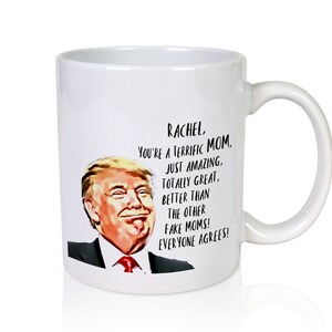 Puede incluir: Taza de caf&eacute; de cer&aacute;mica blanca con una imagen en blanco y negro de un hombre con corbata roja y el texto "Rachel, You're a terrific Mom, Just amazing, Totally great, Better than the other fake moms! Everyone agrees!"