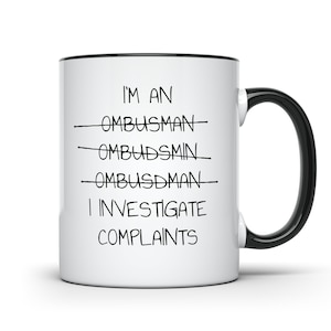 May include: White ceramic mug with a black rim and handle. The mug has black text that reads "I'm an Ombudsman I investigate complaints".