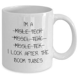 May include: White ceramic coffee mug with black text that reads "I'm a Missile Tech I look after the Boom Tubes".