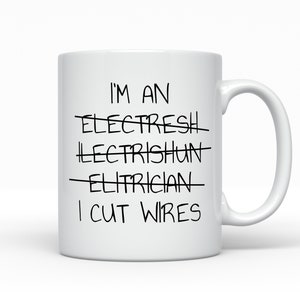 May include: White ceramic mug with the text "I'M AN ELECTRICIAN I CUT WIRES" in black. The words "ELECTRESH", "LECTRISHUN", and "ELITRICIAN" are crossed out. The mug has a curved handle and is set against a white background.
