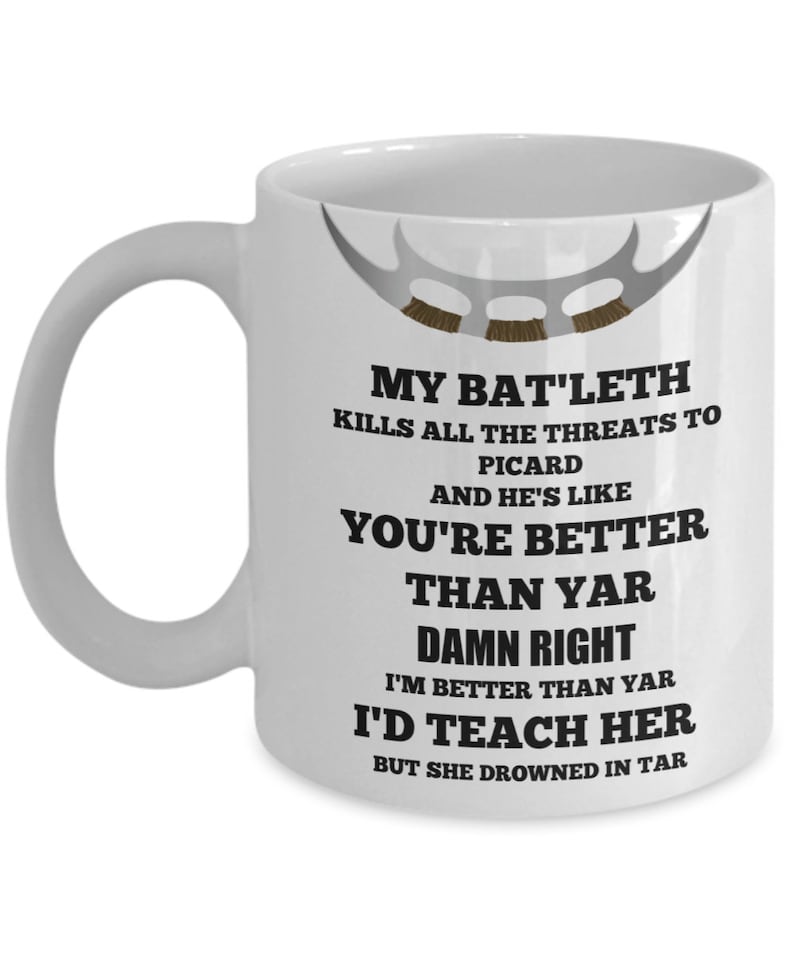 May include: White ceramic coffee mug with a black and white graphic design. The design features a Klingon Bat'leth weapon and text that reads "My Bat'leth kills all the threats to Picard and he's like you're better than yar damn right I'm better than yar I'd teach her but she drowned in tar."