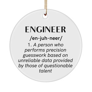 May include: A white, round ceramic ornament with the word "ENGINEER" in bold black letters. Below, the definition humorously describes an engineer's work. A gold string is attached for hanging.