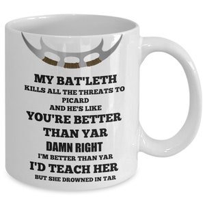 May include: White ceramic mug with a black and white graphic of a Star Trek: Voyager ship. The text on the mug reads "My Bat'leth kills all the threats to Picard and he's like you're better than yar. Damn right I'm better than yar. I'd teach her but she drowned in tar."