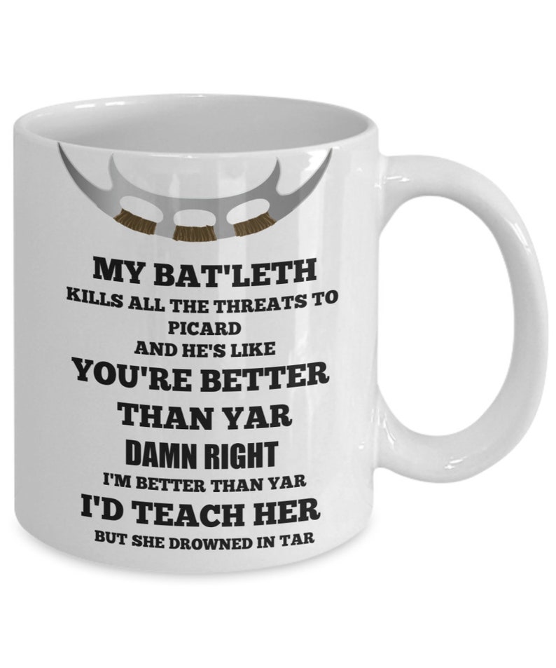 May include: White ceramic mug with a black and white graphic of a Star Trek: Voyager ship. The text on the mug reads "My Bat'leth kills all the threats to Picard and he's like you're better than yar. Damn right I'm better than yar. I'd teach her but she drowned in tar."