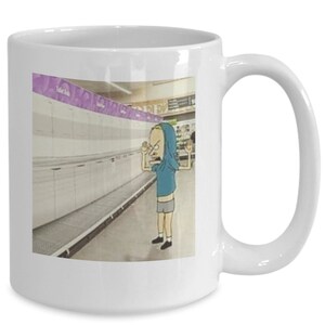 May include: White ceramic coffee mug with a cartoon image of a person in a blue hoodie standing in a grocery store aisle with empty shelves. The person is looking at the camera with a frustrated expression.
