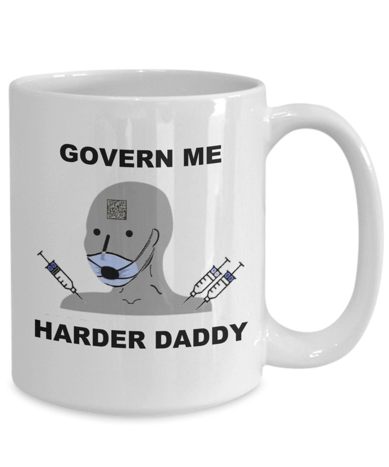 May include: White ceramic mug with the text "GOVERN ME HARDER DADDY" in black. The mug features a gray cartoon figure wearing a blue face mask and holding syringes. A QR code is above the figure's head.