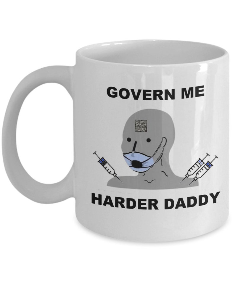 May include: White ceramic mug with a handle. The mug features a meme-style graphic with a masked face, syringes, and the text "GOVERN ME HARDER DADDY" in black. The mug is designed for hot or cold drinks.