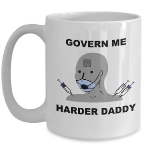 May include: White ceramic mug with a handle, featuring the text "GOVERN ME HARDER DADDY" in black. The mug has a cartoon image of a person wearing a face mask and holding syringes.