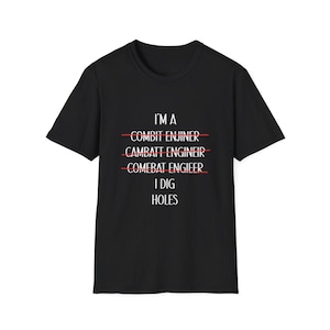 May include: A black short-sleeved t-shirt featuring white text that reads I'M A, followed by three crossed-out lines of misspelled words: COMBIT ENJINER, CAMBATT ENGINEIR, and COMEBAT ENGIEER, with the final line reading I DIG HOLES in white text.