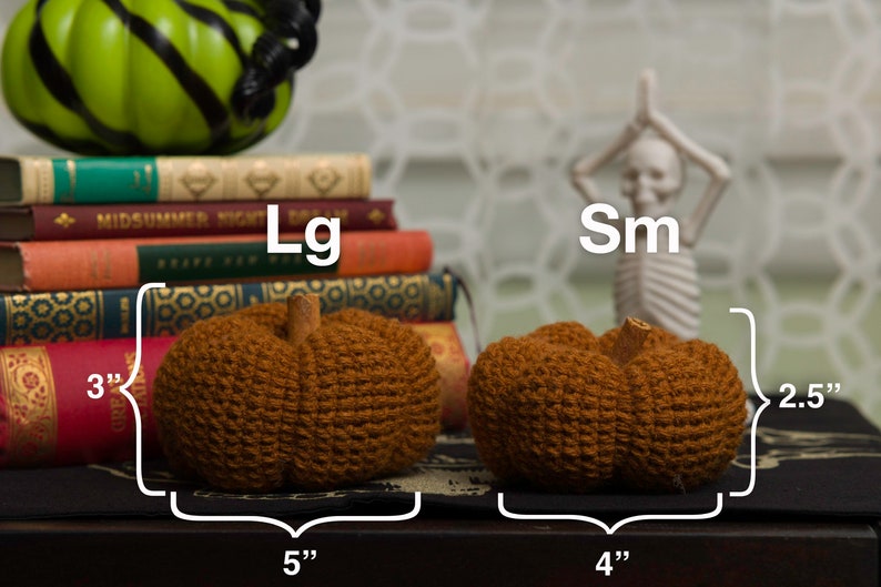 May include: Two crocheted pumpkins, one labeled "Lg" and measuring 5 inches wide and 3 inches tall, and the other labeled "Sm" and measuring 4 inches wide and 2.5 inches tall.