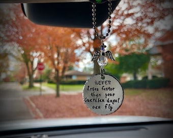 May include: A silver car charm with a beaded chain and a small angel charm. The charm has the text "NEVER drive faster than your guardian angel can fly" on it.