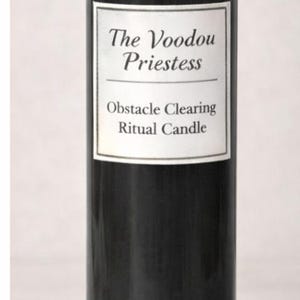 May include: A tall, cylindrical glass candle with black wax and a label that reads "The Voodoo Priestess Obstacle Clearing Ritual Candle." The top is filled with small, colorful stones and herbs.