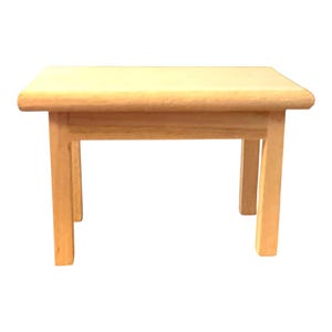 May include: A small, light-colored wooden table with a rectangular top and four straight legs. The surface of the table is smooth and features a natural wood grain pattern. The structure is simple, consisting of a flat top and four vertical supports.