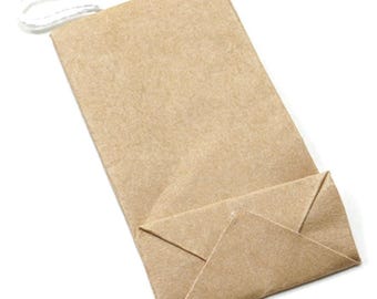 May include: A small, folded brown paper bag with a white string handle. The bag is rectangular with a folded bottom, designed to stand upright. The paper has a slightly textured appearance.