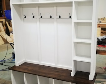 Könnte beinhalten: Weiße Holzbank für den Eingangsbereich mit einer braunen, gebeizten Oberseite, vier Fächern und einem Regal mit vier Haken.