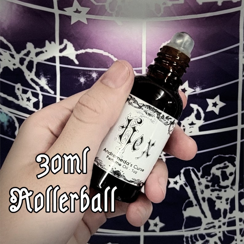 Puede incluir: Un frasco de aceite de perfume de 30 ml con bola, etiquetado como "Andromeda's Curse Perfume Oil - 1oz" con una etiqueta en blanco y negro que presenta la palabra "Flex" en una fuente decorativa.