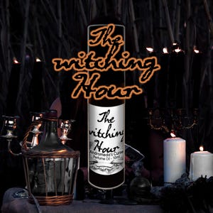 Op de afbeelding: Een zwarte parfumolie fles met de tekst "The Witching Hour" in oranje letters. De fles heeft een wit etiket met de tekst "Andromeda's Curse Perfume Oil - 10ml". De afbeelding heeft een donker, mystiek thema met kaarsen en een decoratieve fles.