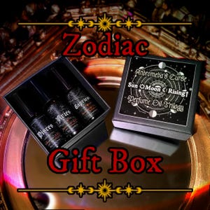 May include: A black gift box set featuring three perfume oil bottles labeled Pisces, Aries, and Capricorn. The box also includes a separate box with the text "Andromeda's Curse Sun Moon Rising Perfume Oil Trilogy". The word "Zodiac" and "Gift Box" are also displayed.