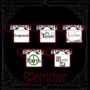 Puede incluir: Cinco frascos de vidrio pequeños con tapas negras, cada uno con una etiqueta blanca con motivos de lunas y hojas negras. Las etiquetas muestran el texto Tempestarii, The Tower, Lichen, Earth y Harpy. La palabra Petrichor está escrita en rojo abajo.