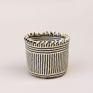 May include: A black and white striped woven basket with a scalloped rim.