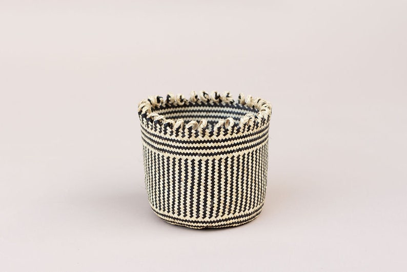 May include: A black and white striped woven basket with a scalloped rim.