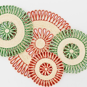 Puede incluir: Cuatro manteles individuales redondos tejidos con ribete verde y naranja. Los manteles individuales están hechos de fibras naturales y tienen un diseño tejido.