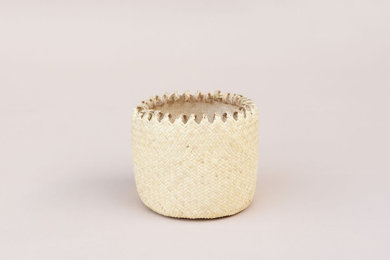 May include: A white woven basket with a decorative trim around the top.