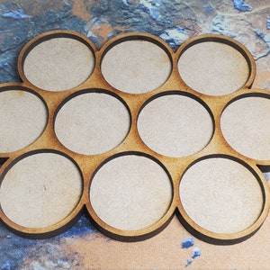 Peut inclure: Un plateau en bois avec dix compartiments circulaires, parfait pour organiser de petits objets. Le plateau est en bois naturel et a un aspect rustique et artisanal.