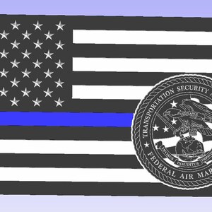 May include: A stylized American flag design with a blue stripe and a Transportation Security Administration Federal Air Marshal emblem. The flag features white stars on a black field and black and white stripes.