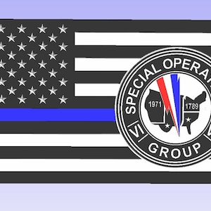 May include: A black and white American flag with a blue stripe across the middle. The flag has a circle in the center with the words "Special Operations Group" and the years "1971" and "1789" inside the circle.