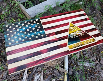 Puede incluir: Una bandera americana de madera con un esquema de color rojo, blanco y azul. La bandera tiene un campo azul con estrellas blancas y rayas rojas y blancas. La bandera también presenta un emblema amarillo y azul con el número 50 y las palabras "Jersey Blues".