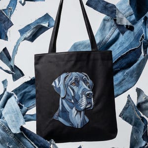 Puede incluir: Bolso tote negro con un retrato de perro hecho con parches de mezclilla. La cabeza del perro es un diseño de patchwork detallado en tonos azules. Trozos de mezclilla rodean el bolso, creando un efecto visual dinámico.