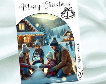 May include: A Christmas card featuring a family of four building a snowman in a snowy winter scene. The card has the text "Merry Christmas" and "The Miller Family" on it.