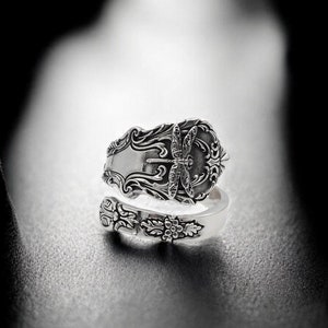 May include: A silver ring made from a vintage spoon with an ornate design featuring a butterfly.
