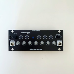 Puede incluir: Teclado de sintetizador electrónico negro con múltiples perillas y botones. El texto "клавиатура" se muestra en el teclado. También son visibles los textos "CV/GATE KEYBOARD" y "MODULAIRE MARITIME".