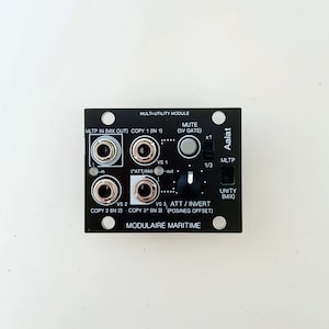 May include: A black modular synthesizer module with multiple input and output jacks, knobs, and text labels. The module is labeled "Multi-Utility Module" and "Modulaire Maritime". The brand name "Aalat" is also visible.